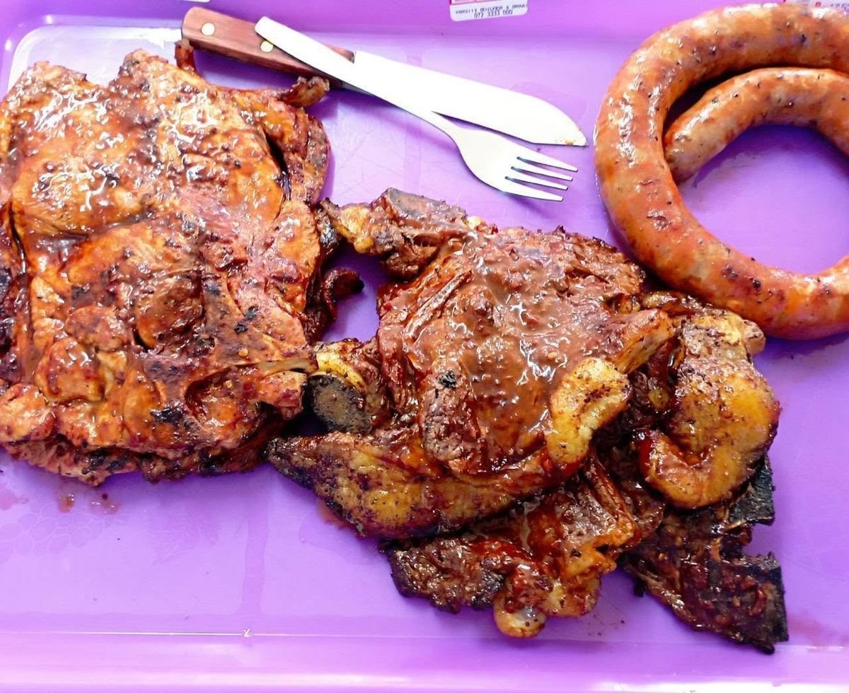 Braaied pork chops, beef and tomato sausage on a tray