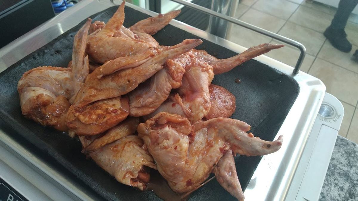 Marinated chicken wings on the scale at the counter